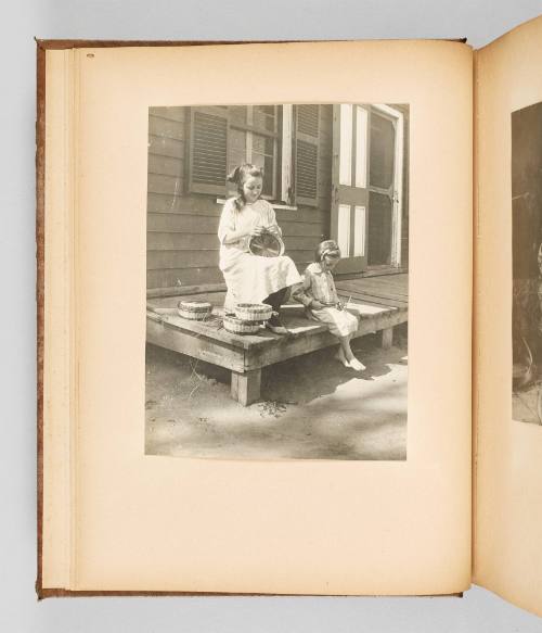 [Two habitant girls create baskets on their porch] Page 10 of The Abenaki; from collection of Canadian albums compiled by Edith S. Watson, 1890s-1930s