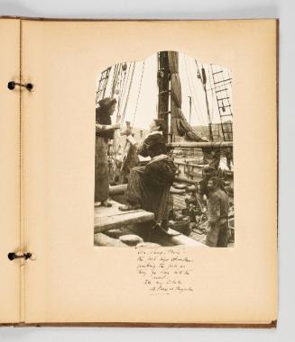 "Un, deux, trois" -- the fish wife [illeg.] counting the fish as they go down into the hold, Isle aux Chien, St. Pierre et Miquelon. Page 47 of Fish; from collection of Canadian albums compiled by Edith S. Watson, 1890s-1930s