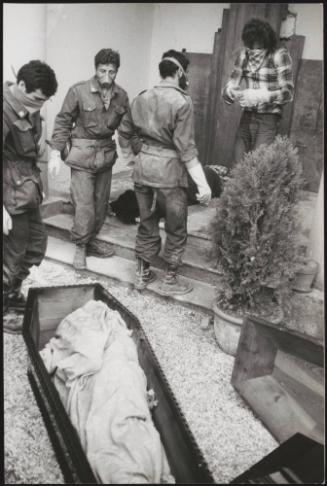 Soldiers and volunteers with covered faces work at preparing the victim's bodies for burial at the Osoppo cemetery after the 1976 Friuli earthquake