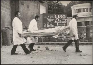 Three men use a mattress as a make shift stretcher to carry a victims body in the aftermath of an earthquake in Tuscany 