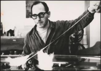 A scientist experimenting with molten glass at the National Laboratories of Frascati, near Rome