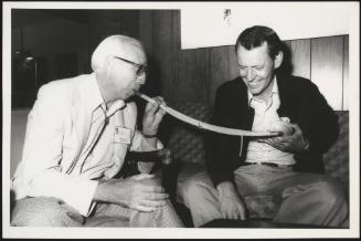 Willem Kolff demonstrates how an artificial organ works whilst it's held by physician Thomas Starzl 