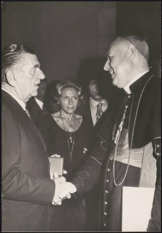 Cardinal Angelo Dell'Acqua shaking hands with Italian entrepreneur Giovanni Borghi