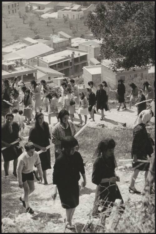 A procession of women and children holding church candles climb a village hill on the day of the 'Candelora' (Candlemas), which is the 2nd of February