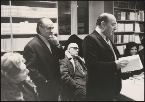 Giuseppe Selvaggi reads to a room of people, including writer Cesare Zavattini, and publisher Toni Bonavita