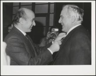 Ciriaco De Mita adjusts another mans tie 