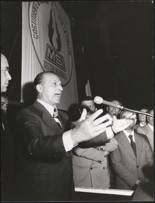 Vito Miceli speaking into a microphone at a meeting of the MSI (Italian Social Movement)