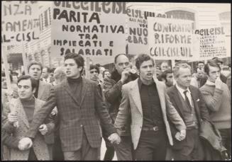 A group of men, part of the labour trade unions, link hands and lead a protest for contract reforms