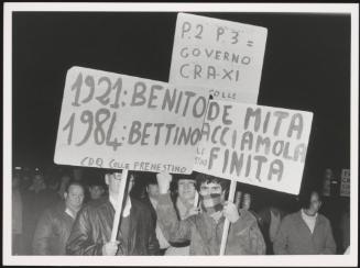 Protesters hold up placards against Italian politician Bettino Craxi, comparing him to dictator Benito Mussolini, and accusing him of involvement in the Masonic Lodge 'P2'