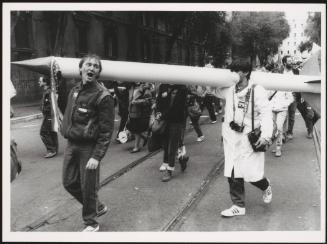 Anti-nuclear protesters walk through the streets holding a large replica rocket