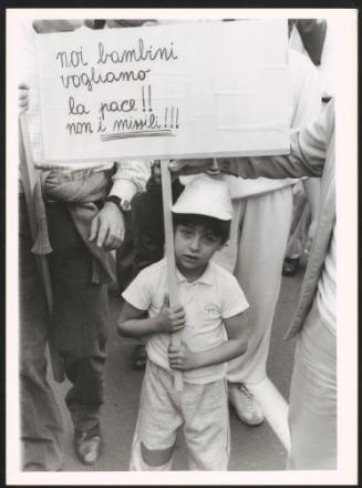 A child holding a banner calling for peace against the nuclear missiles