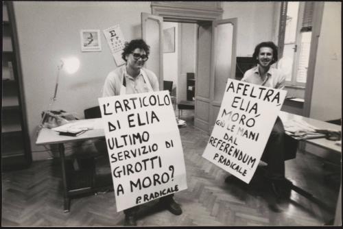 Two men from the Radical Party stand with  banners around their neck in protest against the newspaper 'Il Giorno' in the Party's headquarters in Rome