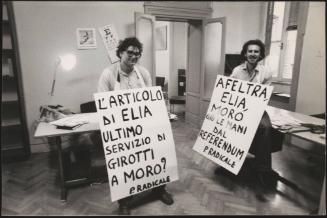 Two men from the Radical Party stand with  banners around their neck in protest against the newspaper 'Il Giorno' in the Party's headquarters in Rome