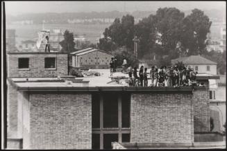 A crowd of protesters on a roof of a prison