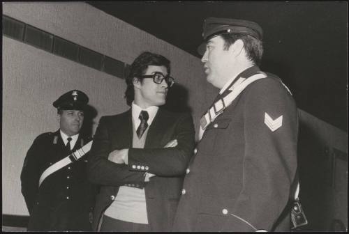 The activist Achille Lollo stands between two officials