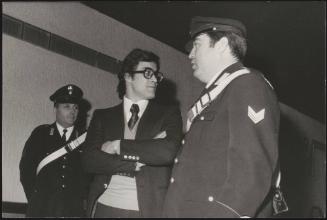 The activist Achille Lollo stands between two officials