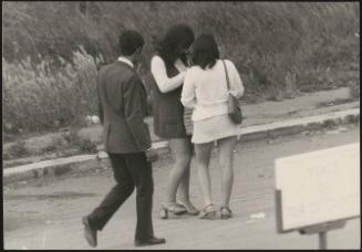 Two prostitutes are approached by a young man in a suit