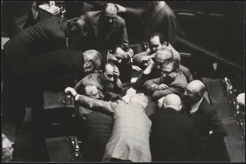 A group of politicians huddle together during a sesion in Parliament 