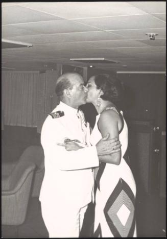 A Naval officer kisses a woman aboard a cruise ship