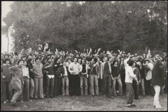 A crowd of protesters take their stand in a field