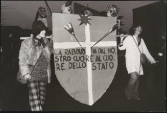 Indiani Metropolitani carry a large cardboard shield 