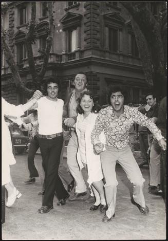 A small group of young men and women run through the street