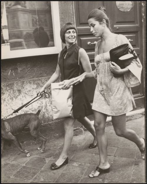 Anna Maria Ferrero walking a dog down the street