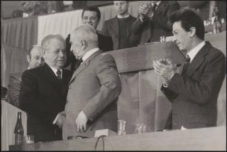 Anshei Kirilenko shakes hands with another man, looked on by Enrico Berlinguer of PCI at PCI congress, March 18th - 23rd 1975, Rome