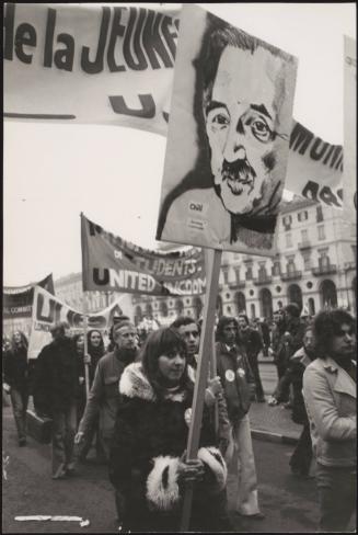 Protesters demonstrate in support of democracy in Chile, a woman holds a placard with a painting of Luis Corvalán who was imprisoned by Augusto Pinochet during the Chilean coup d'état