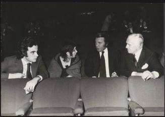 The actor and director Vittorio De Sica sitting in a cinema with his son Christian (far left) 