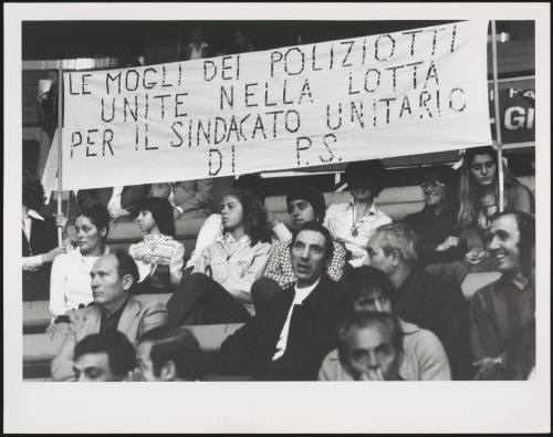 Wives of policeman hold a banner proclaiming their support for the Police union