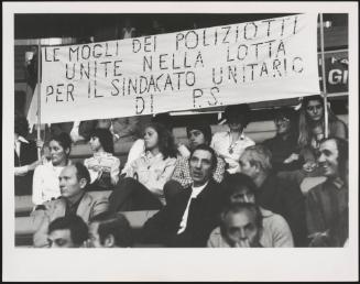 Wives of policeman hold a banner proclaiming their support for the Police union