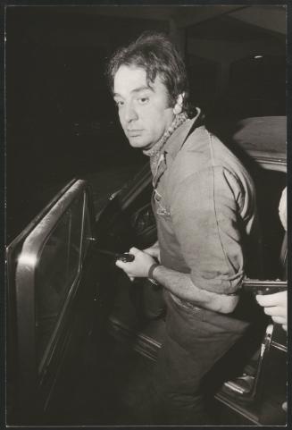 An undercover police man gets into a car holding a gun