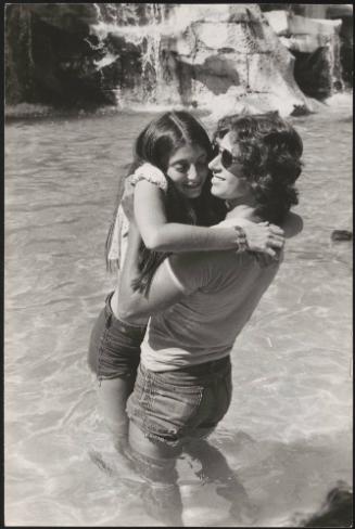 An Italian 'Pappagalli' man picks up a female tourist at the Trevi fountains, Rome
