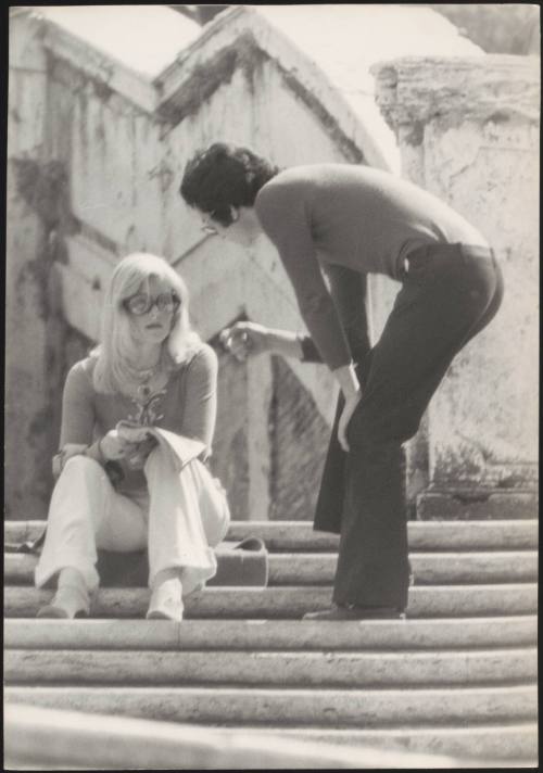 An Italian 'Pappagalli' man approaches a femlae tourist on the steps of Trinità dei Monti, Rome