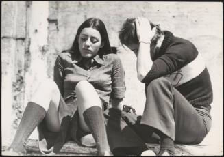 An Italian 'Pappagalli' man sits with a female tourist  near the Spanish Steps, Rome