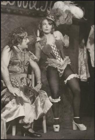 A man in a dress and a woman in stockings and corset during a cabaret 