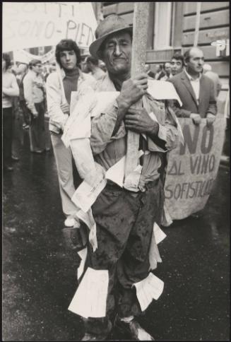 Portrait of a demonstrator with pieces of paper made to look like promissory notes pinned on his clothes, at a winemaker's rally