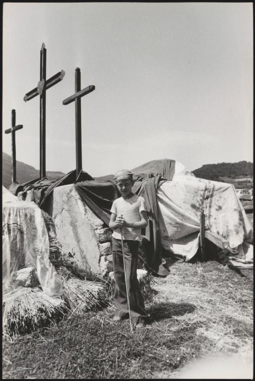 A young boy working on farmland in Pescolanciano, in the Molise region of southern Italy, photographed underneath three large crucifixes