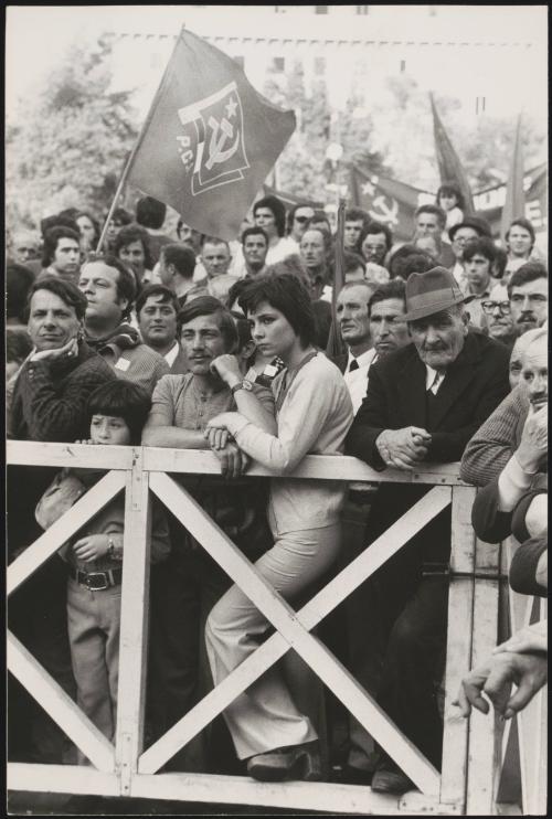 A large crowd of Italian Communist Party supporters waiting behind white gates