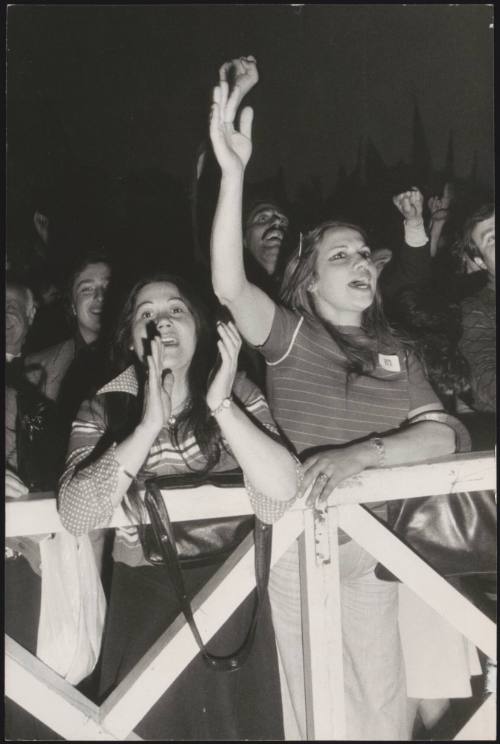 A young crowd cheers and claps as they get ready to meet politician Enrico Berlinguer