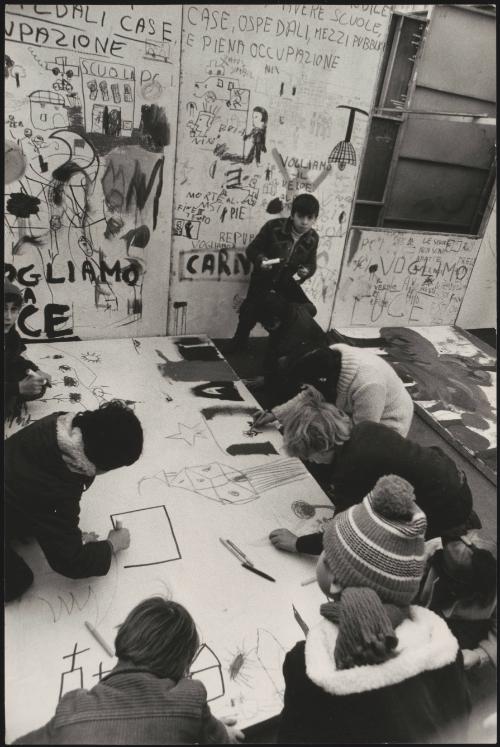 Students and young people writing protest slogans and drawing on the walls and floor of a studio