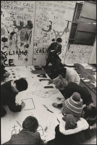 Students and young people writing protest slogans and drawing on the walls and floor of a studio