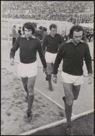 Football players from AS Roma, Santarini, Scarlatti and Salvori walk onto the pitch