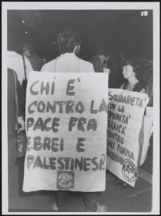 A demonstrator wears a protest placard highlighting the Israeli–Palestinian conflict