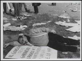 A man sleeping on a placard during the aftermath of worker's demonstration