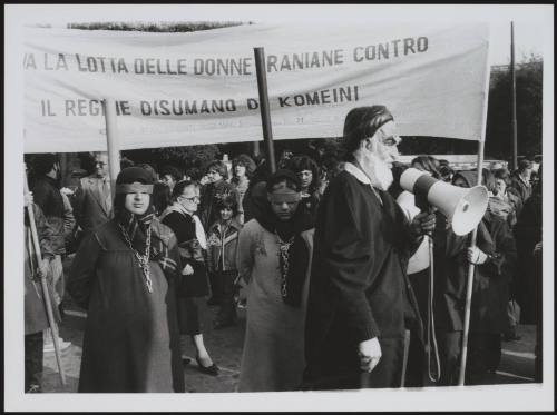 A man in a caricature mask of Iranian leader Komeini, leading a protest to highlight the plight of women under his regime