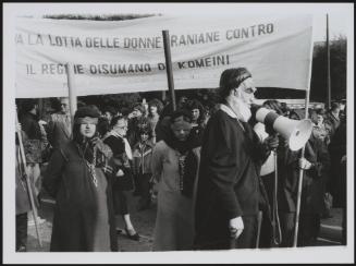 A man in a caricature mask of Iranian leader Komeini, leading a protest to highlight the plight of women under his regime