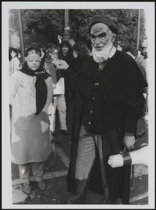 A masked charicature of Iranian leader Khomeini in a satirical re-enacment of the leader imprisoning and executing members of the opposition 