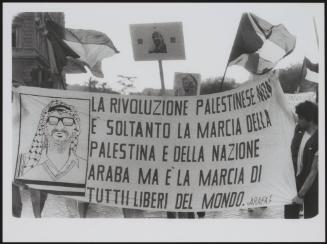 People hold a banner with a drawing of Yasser Arafat, that reads 'The Palestinian revolution is not only the march of Palestine and the Arab but of all those who are free around the world'